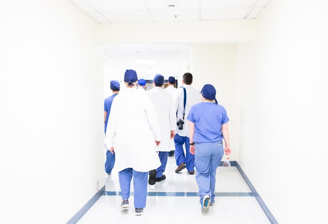 Healthcare professionals in hospital walking away from viewer